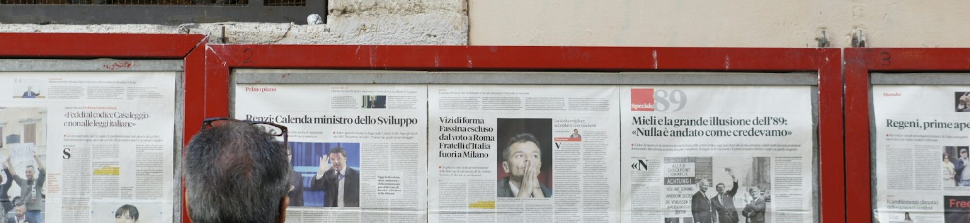 man reading newspaper in bulletin board